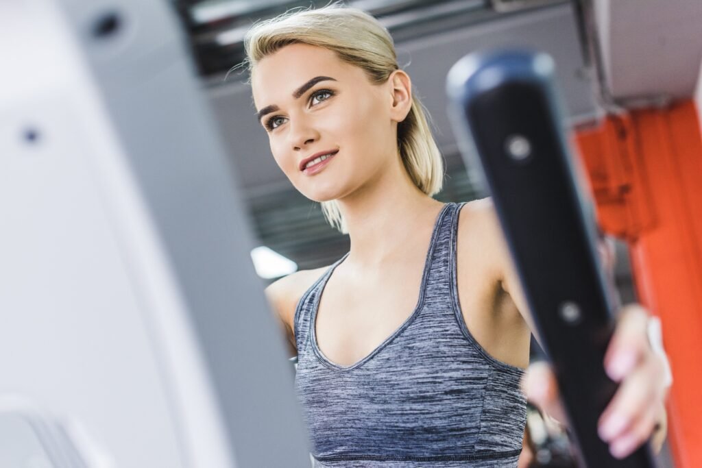 close-up shot of woman working out on elliptical machine at gym