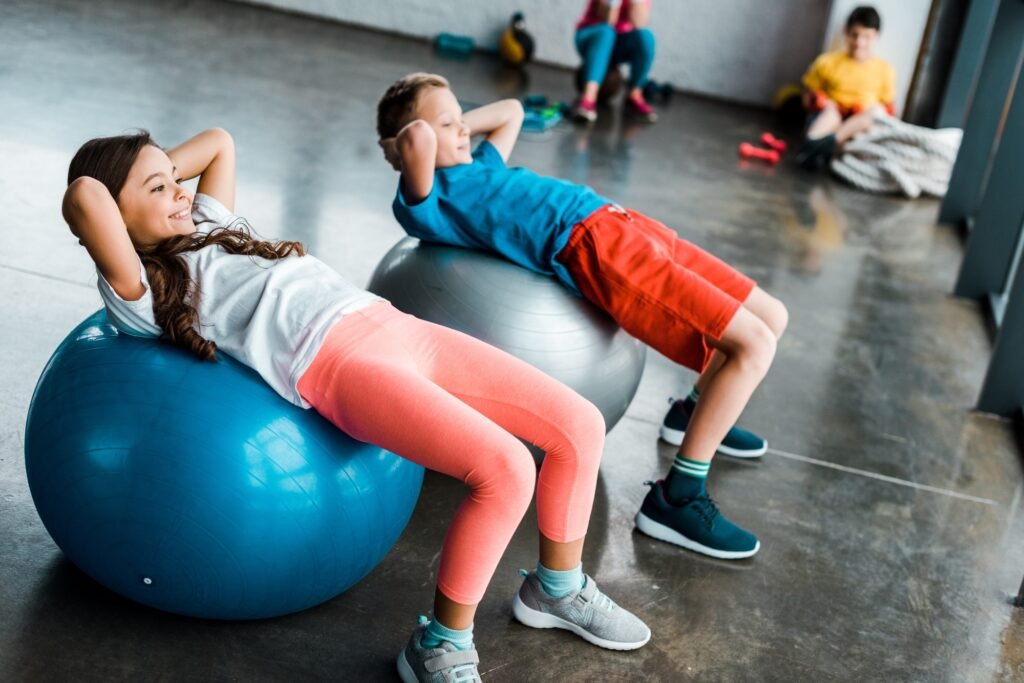 Kids doing abs exercise with fitness balls