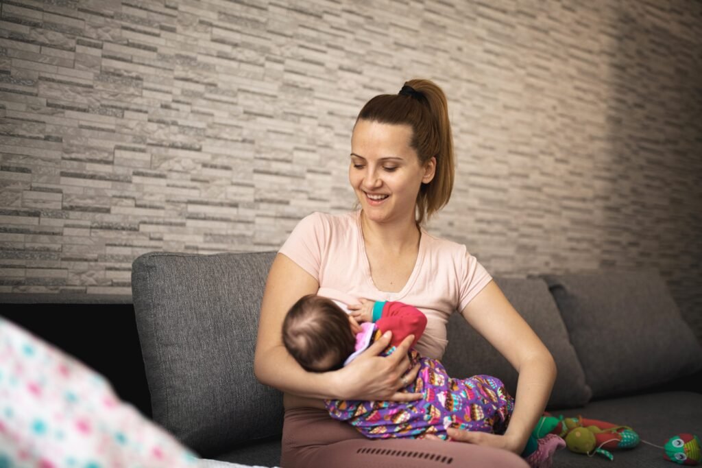 Mother breastfeeding her baby in a cozy living room setting